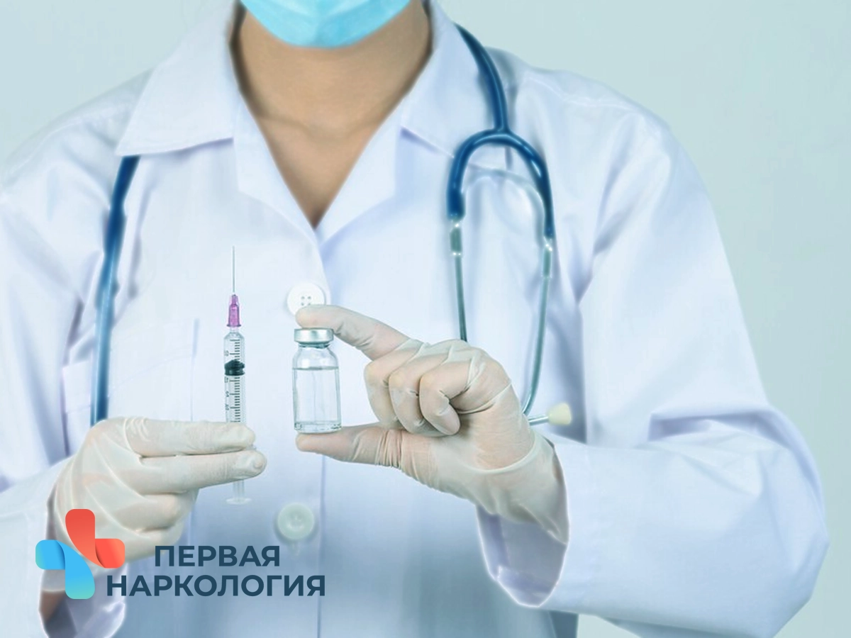 Врач держит шприц и ампулу с лекарством